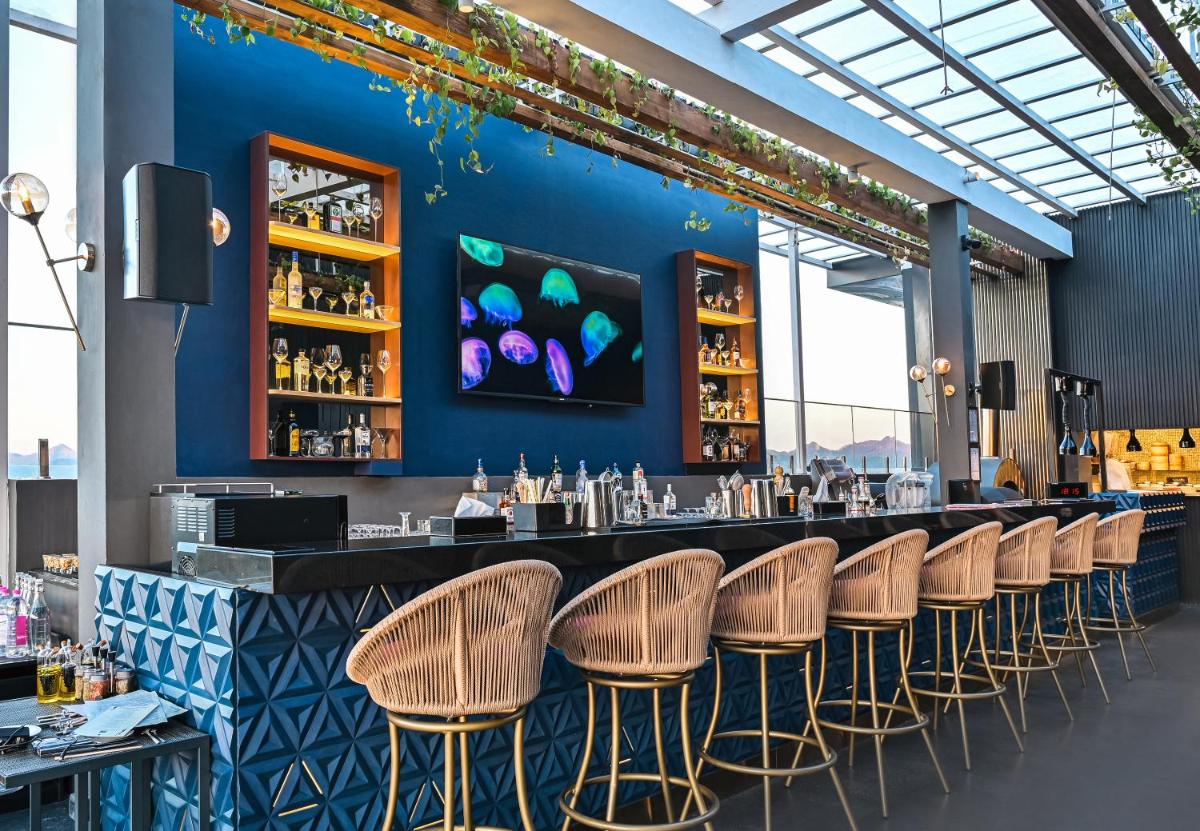 a bar with rattan chairs and a blue wall at Parallel Hotel Udaipur, a member of Radisson Individuals in Udaipur