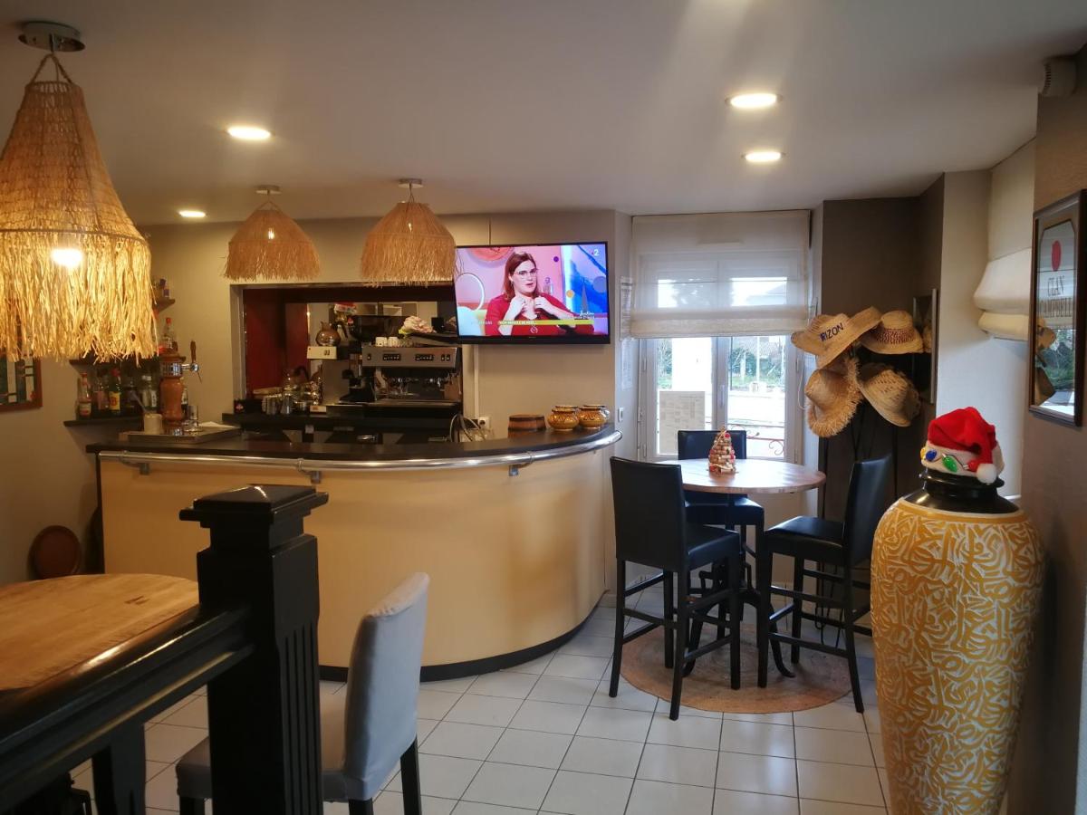 une cuisine avec un bar et une table avec des chaises dans l'établissement Logis Hôtel Bellevue, à Bessines-sur-Gartempe