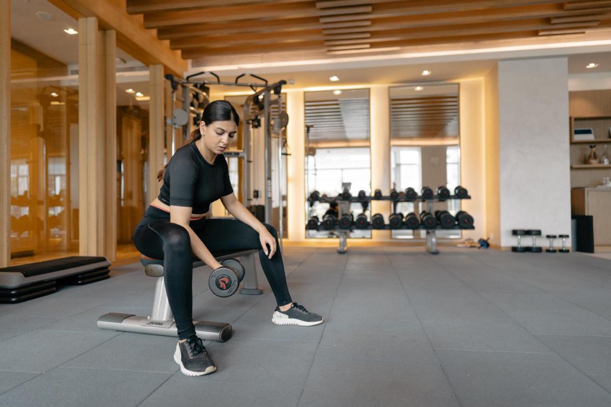 a woman sitting on a bench in a gym at Hyatt Regency Ahmedabad in Ahmedabad