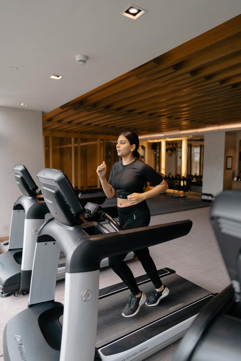 a man standing on a treadmill in a gym at Hyatt Regency Ahmedabad in Ahmedabad