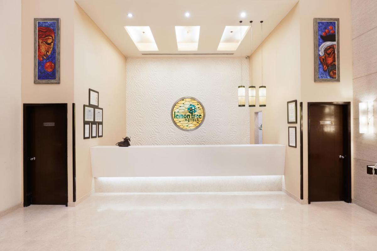 a lobby with a large white counter in a building at Lemon Tree Premier, Ulsoor Lake, Bengaluru in Bengaluru