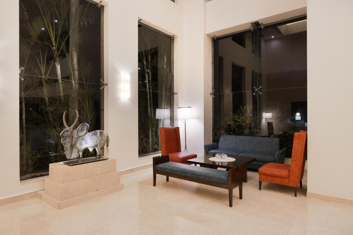 a living room with a couch and a table at Lemon Tree Premier, Ulsoor Lake, Bengaluru in Bengaluru