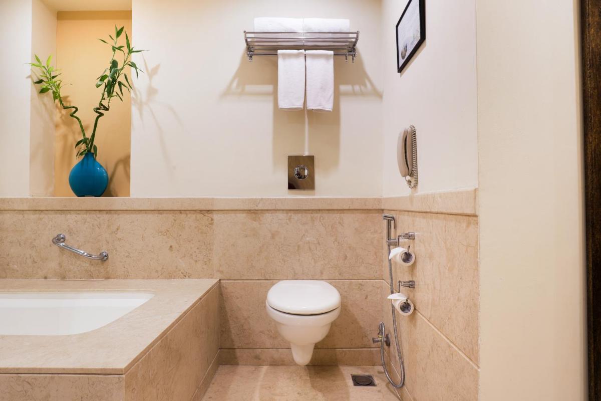 a bathroom with a toilet and a sink at Lemon Tree Premier, Ulsoor Lake, Bengaluru in Bengaluru