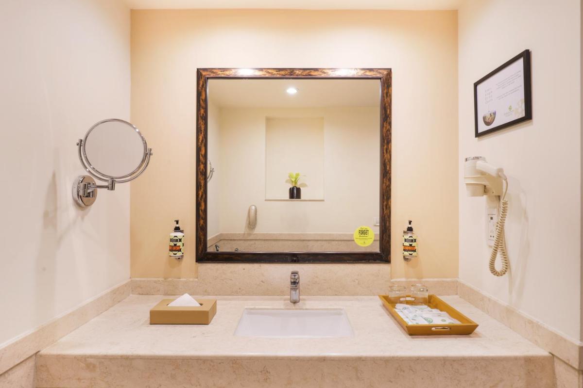 a bathroom with a sink and a mirror at Lemon Tree Premier, Ulsoor Lake, Bengaluru in Bengaluru