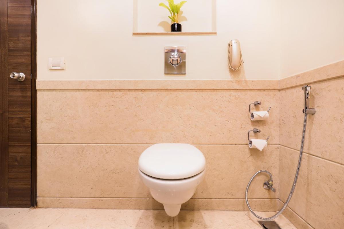 a bathroom with a toilet and a shower at Lemon Tree Premier, Ulsoor Lake, Bengaluru in Bengaluru
