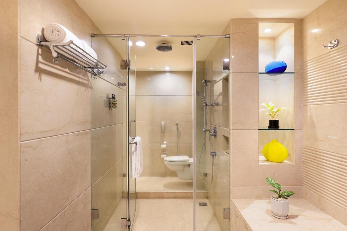 a bathroom with a glass shower with a toilet at Lemon Tree Premier, Ulsoor Lake, Bengaluru in Bengaluru a bathroom with a glass shower with a toilet at Lemon Tree Premier, Ulsoor Lake, Bengaluru in Bengaluru