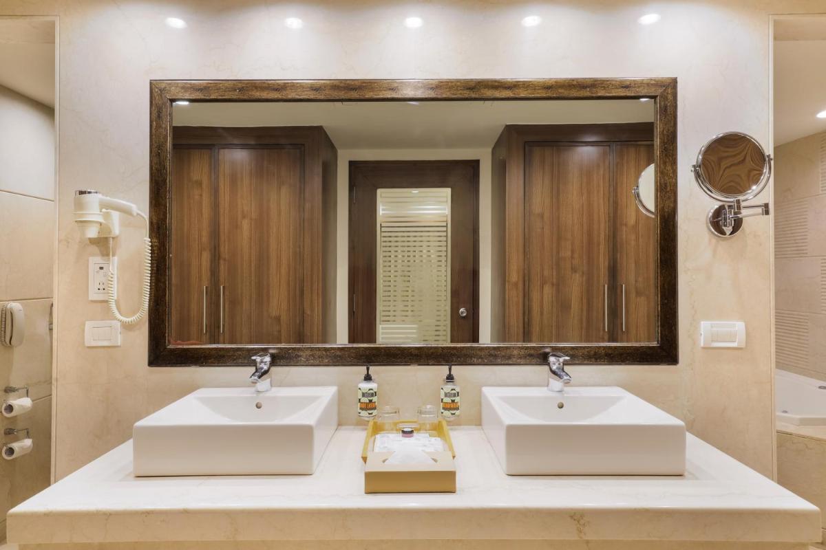 a bathroom with two sinks and a large mirror at Lemon Tree Premier, Ulsoor Lake, Bengaluru in Bengaluru