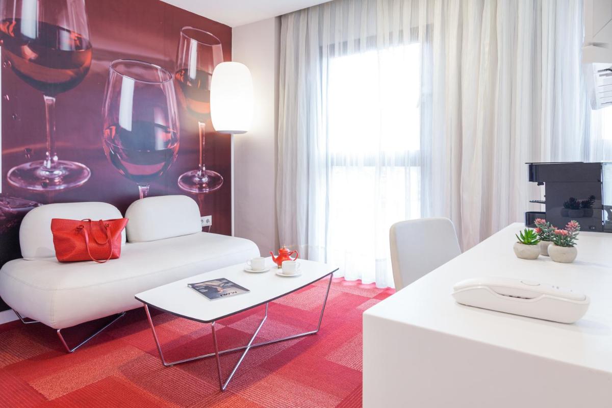 Una televisión o centro de entretenimiento en Hotel Maciá Granada Five Senses Rooms & Suites