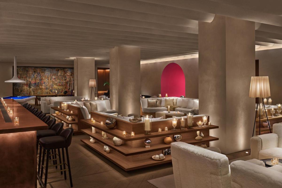 Un vestíbulo de un hotel con un bar y sillas. en The Madrid EDITION, en Madrid