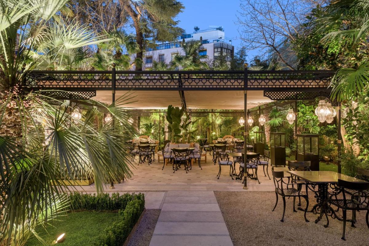 un patio con mesas y sillas y un puente en Santo Mauro, a Luxury Collection Hotel, Madrid, en Madrid