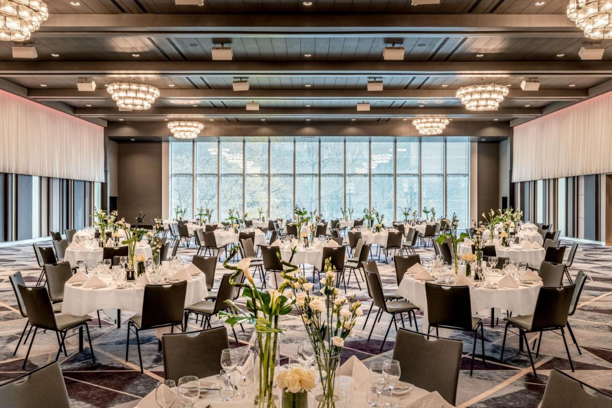 einen großen Bankettsaal mit Tischen und Stühlen in der Unterkunft Frankfurt Marriott Hotel in Frankfurt am Main einen großen Bankettsaal mit Tischen und Stühlen in der Unterkunft Frankfurt Marriott Hotel in Frankfurt am Main