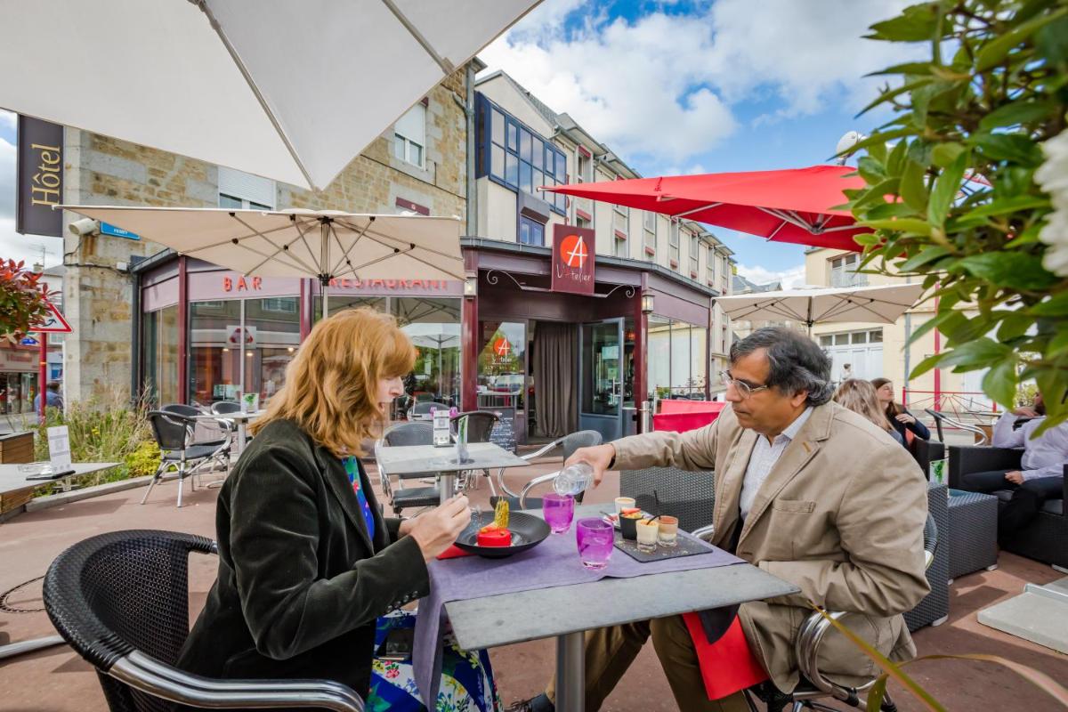 un homme et une femme assis à une table dans un restaurant dans l'établissement Logis Hôtel Restaurant Le Fruitier, à Villedieu-les-Poêles