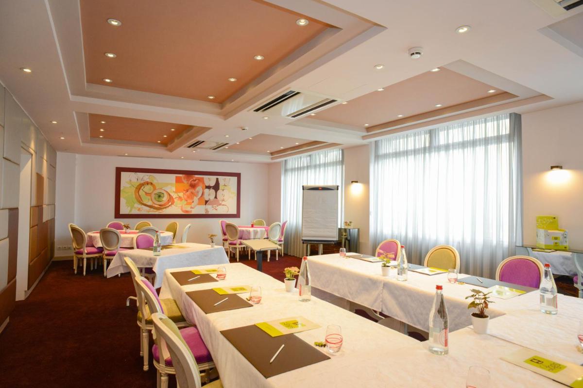 un restaurant avec des tables, des chaises et un tableau noir dans l'établissement Logis Hôtel Restaurant Le Fruitier, à Villedieu-les-Poêles