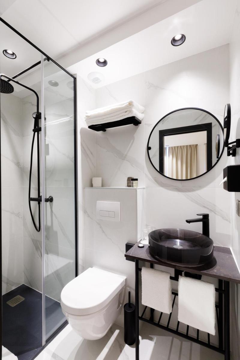 une salle de bain avec toilettes, lavabo et miroir dans l'établissement Star Champs-Elysées, à Paris