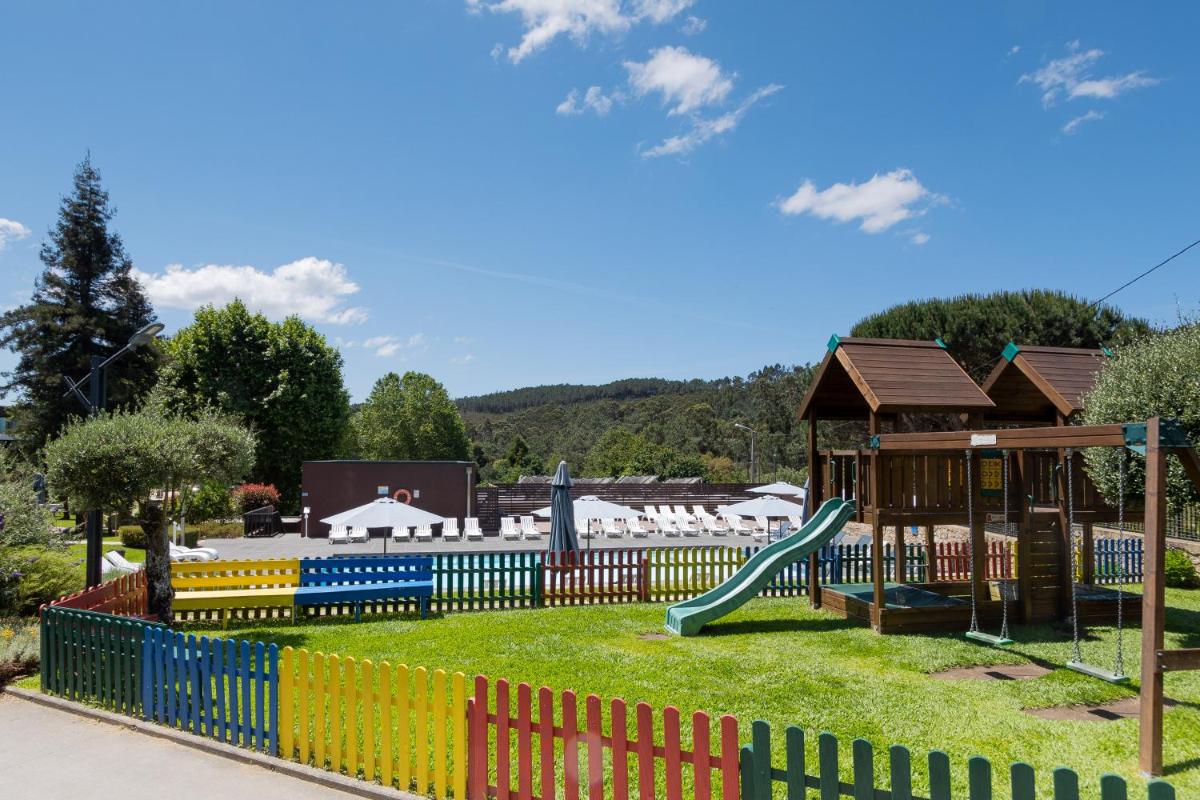 um parque infantil com um escorregador e uma estrutura de brincar em Prazer da Natureza Resort & Spa em Caminha
