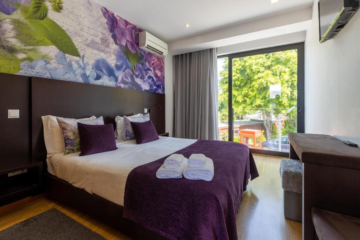 um quarto de hotel com uma cama com dois chinelos em cima em Prazer da Natureza Resort & Spa em Caminha mais 74 fotografias