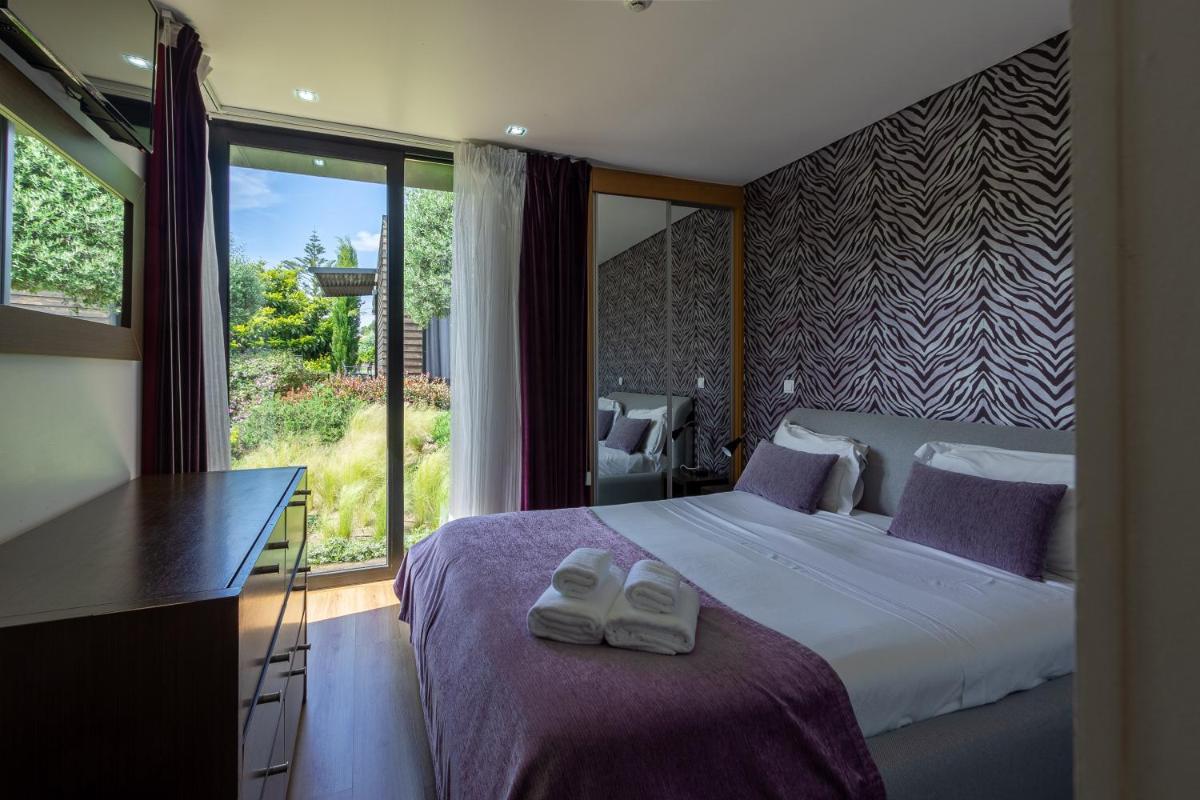 um quarto com uma cama com dois sapatos brancos em cima em Prazer da Natureza Resort & Spa em Caminha