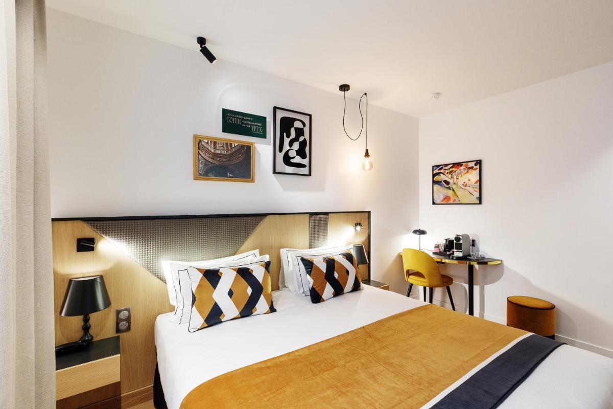 une chambre d'hôtel avec un lit et un bureau dans l'établissement Star Champs-Elysées, à Paris