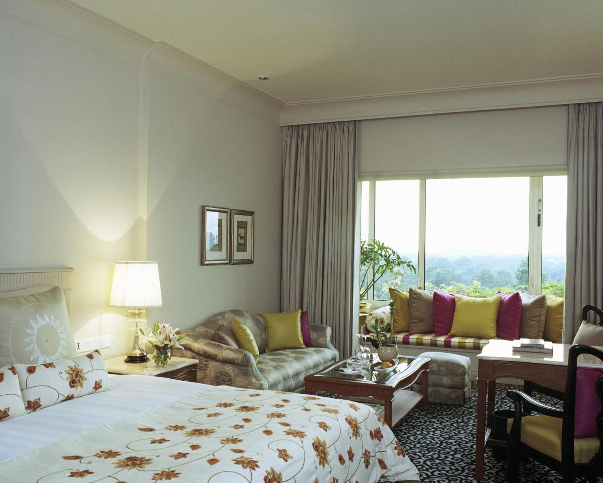 a hotel room with a bed and a living room at Taj Bengal in Kolkata