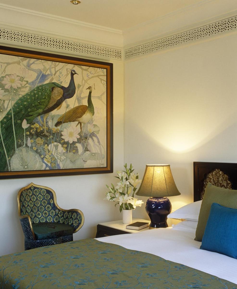 a hotel room with a bed and a painting on the wall at Taj Bengal in Kolkata