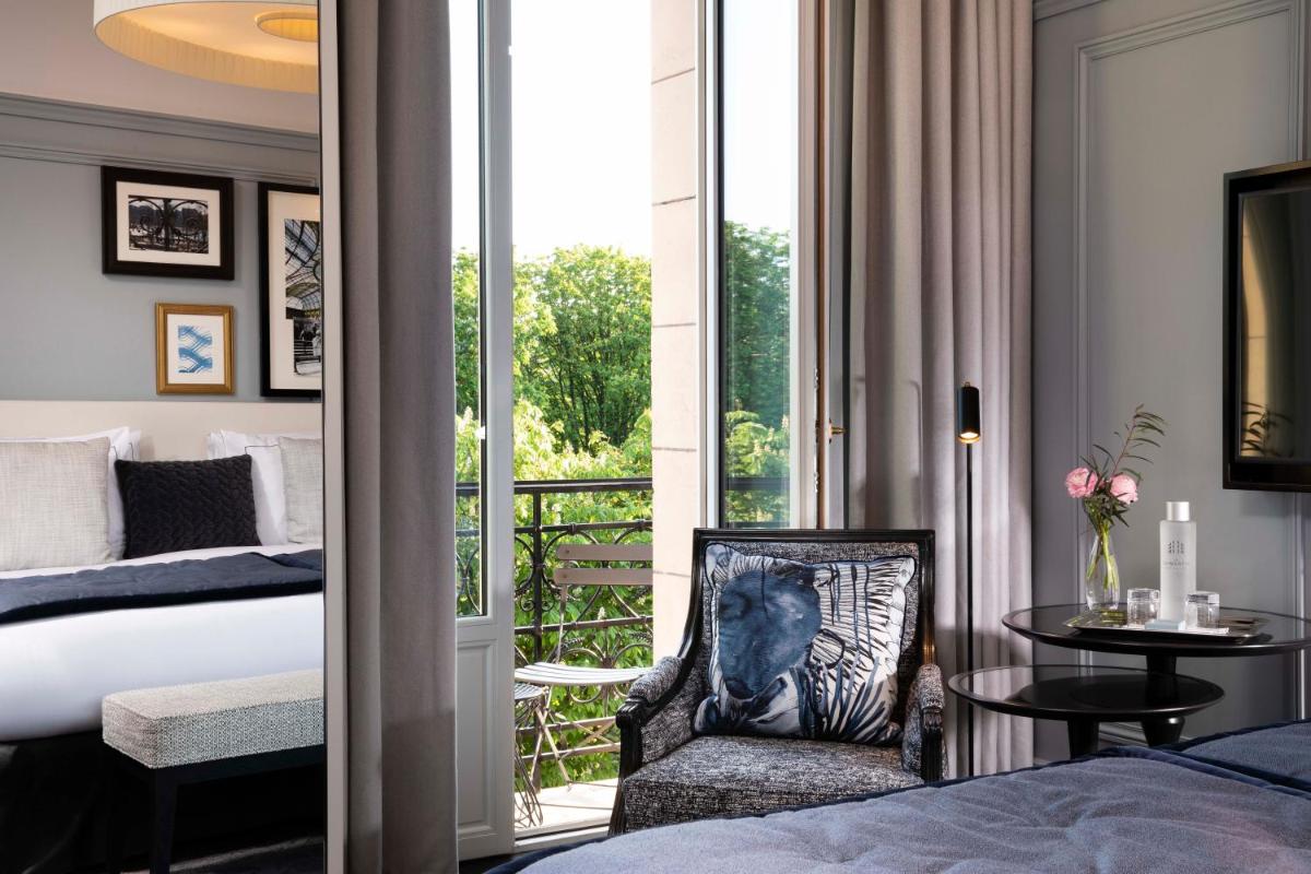 - une chambre avec un lit, une chaise et un balcon dans l'établissement Le Damantin Hôtel & Spa, à Paris