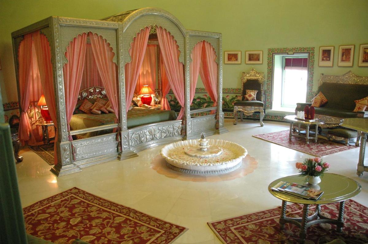 a living room with a bed and a table at Shiv Niwas Palace by HRH Group of Hotels in Udaipur