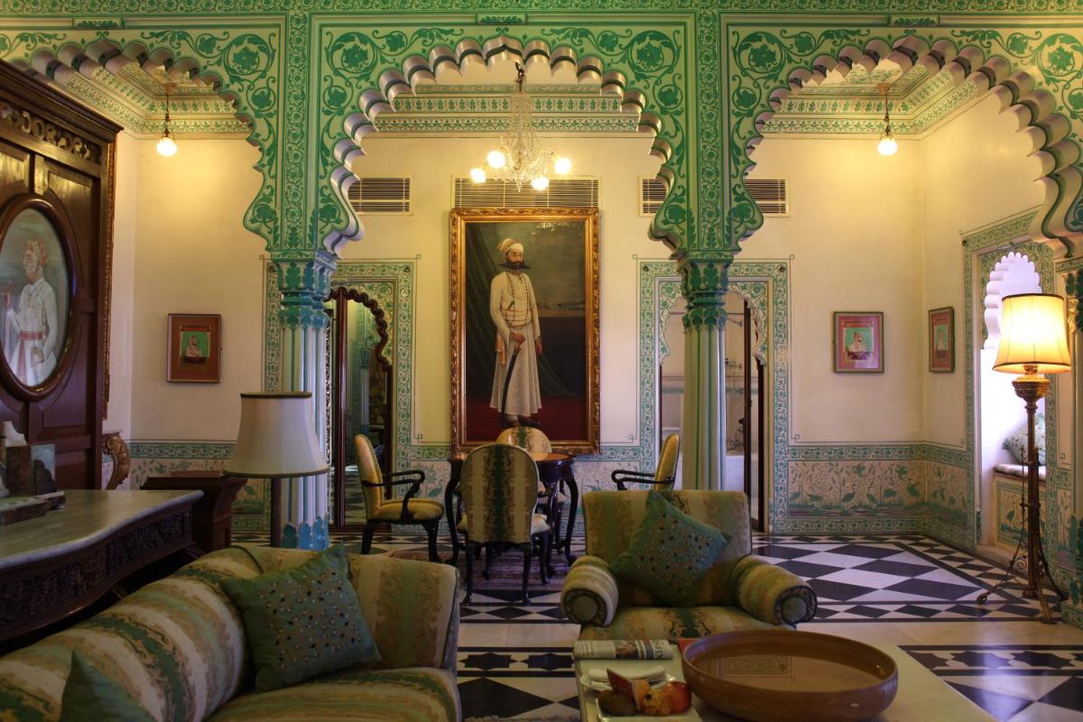 a living room with a couch and a painting on the wall at Shiv Niwas Palace by HRH Group of Hotels in Udaipur