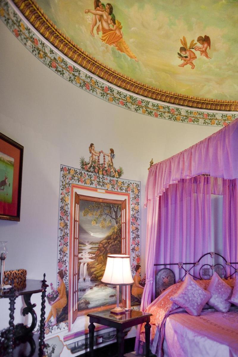 a bedroom with a bed with a painting on the ceiling at Shiv Niwas Palace by HRH Group of Hotels in Udaipur