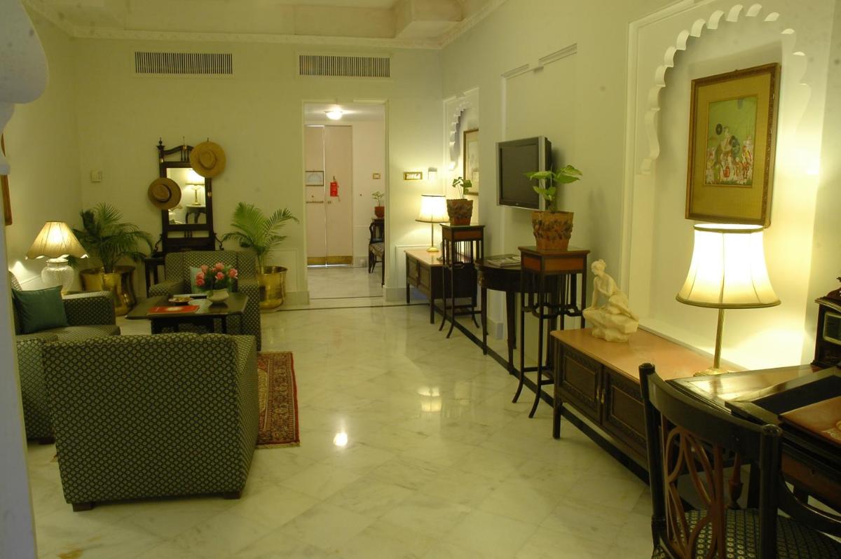 a living room with a couch and tables and chairs at Shiv Niwas Palace by HRH Group of Hotels in Udaipur