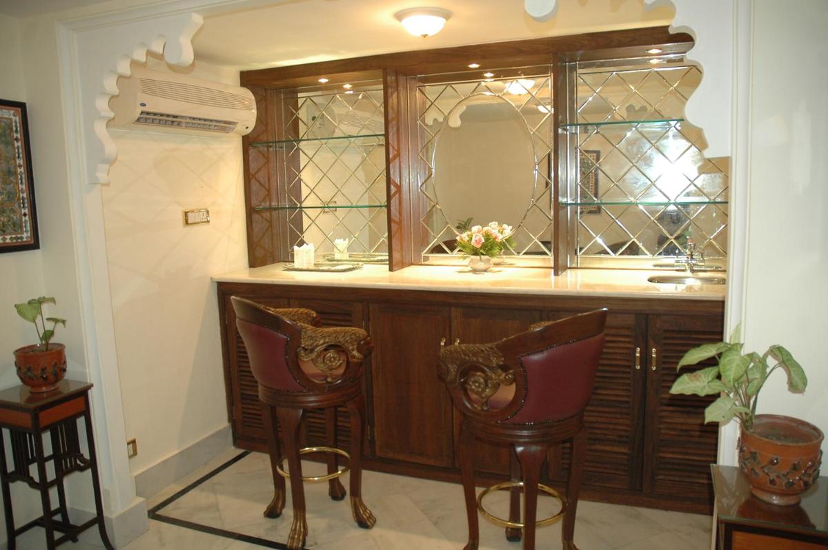 a bathroom with a vanity with a mirror and two chairs at Shiv Niwas Palace by HRH Group of Hotels in Udaipur