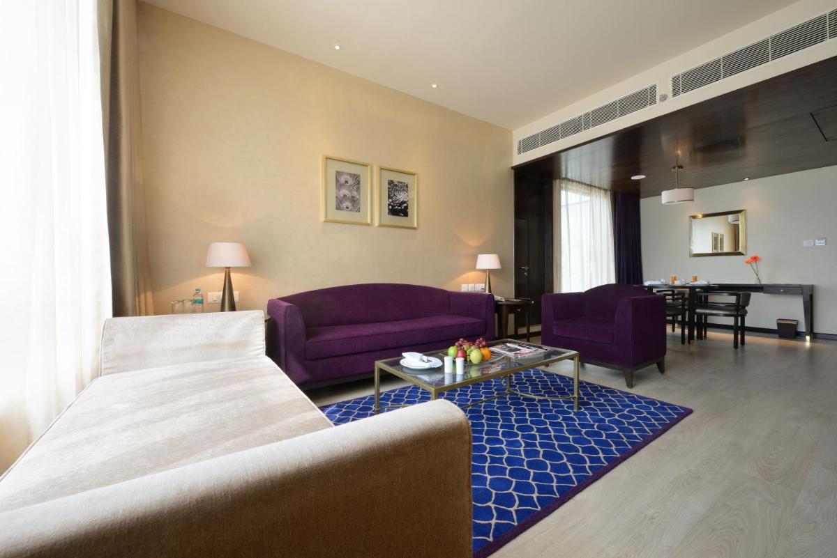 a living room with a bed and purple furniture at Marasa Sarovar Premiere in Tirupati