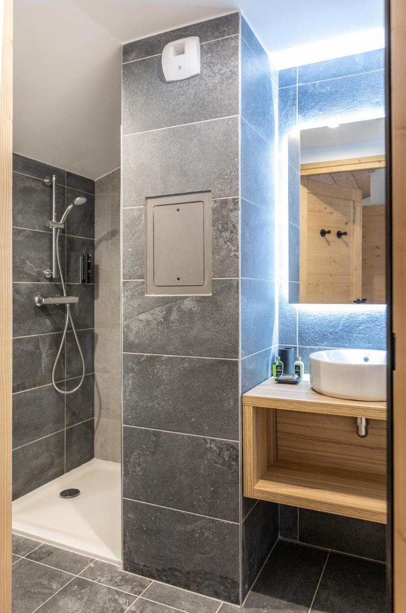 une salle de bain avec douche et lavabo dans l'établissement TERRESENS - Le Snoroc, à Aime La Plagne
