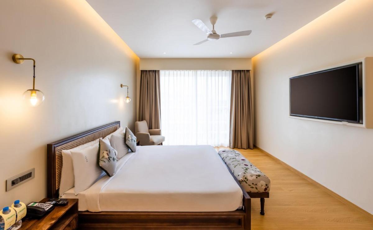 a hotel room with a bed and a flat screen tv at Holiday Inn Goa Candolim in Candolim a hotel room with a bed and a flat screen tv at Holiday Inn Goa Candolim in Candolim