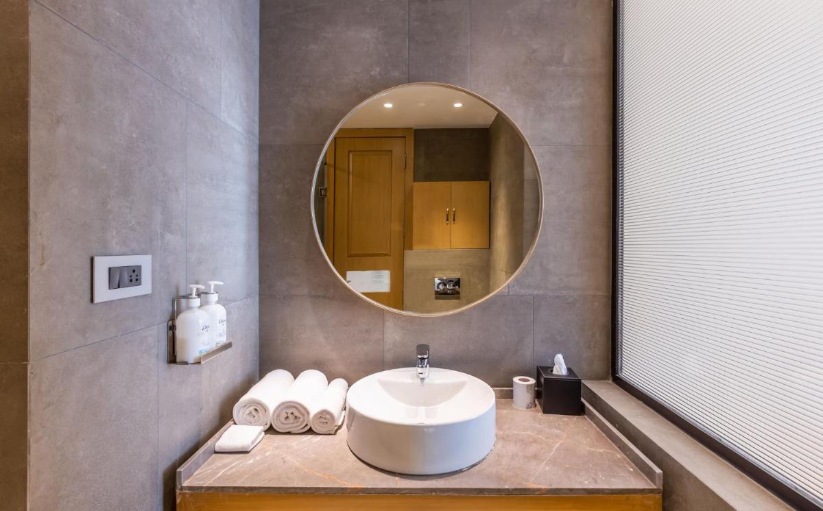 a bathroom with a sink and a mirror at Holiday Inn Goa Candolim in Candolim a bathroom with a sink and a mirror at Holiday Inn Goa Candolim in Candolim