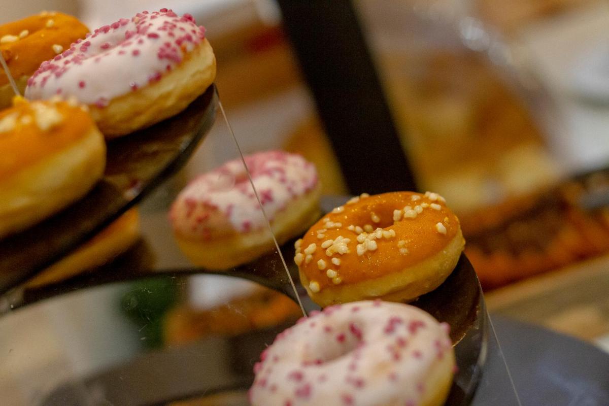 um monte de donuts com granulado em uma prateleira em In Gold Hotel & Spa em Águeda
