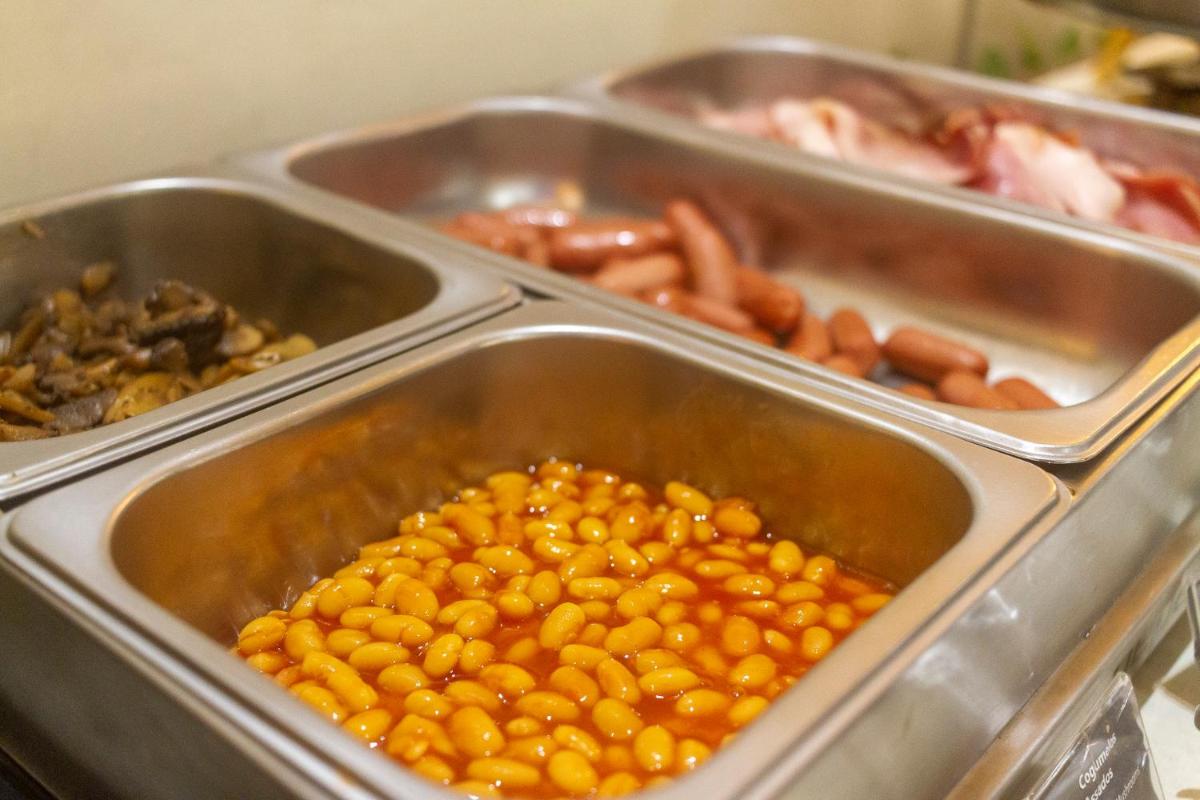 uma bandeja de comida com feijão e outros alimentos em In Gold Hotel & Spa em Águeda