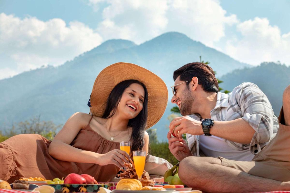 a group of people sitting around a picnic at Hyatt Regency Dehradun Resort and Spa in Dehradun