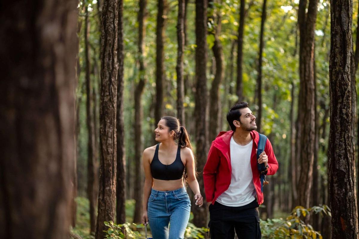 a man and a woman walking through a forest at Hyatt Regency Dehradun Resort and Spa in Dehradun