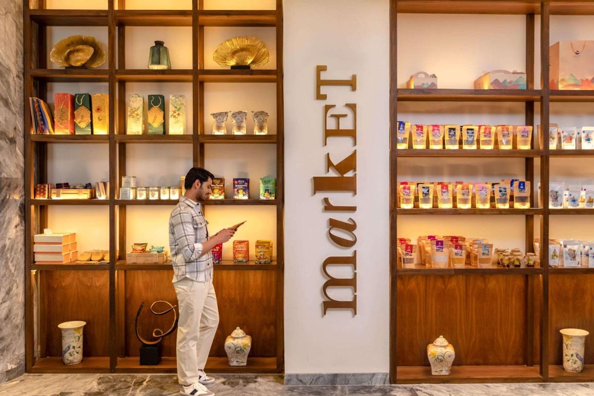a man standing in front of a book shelf at Hyatt Regency Dehradun Resort and Spa in Dehradun