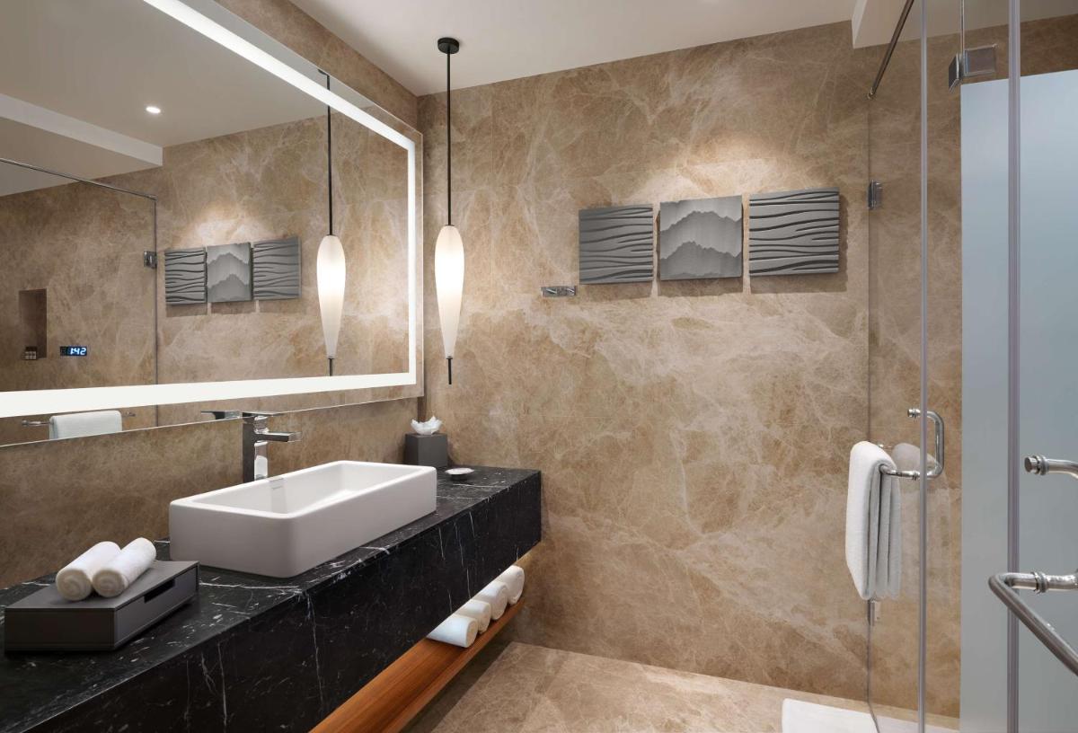 a bathroom with a sink and a mirror at Hyatt Regency Dehradun Resort and Spa in Dehradun