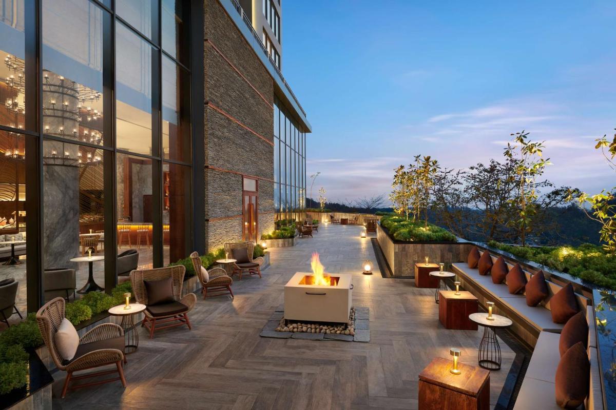 an outdoor patio with a fire pit and a building at Hyatt Regency Dehradun Resort and Spa in Dehradun +73 photos