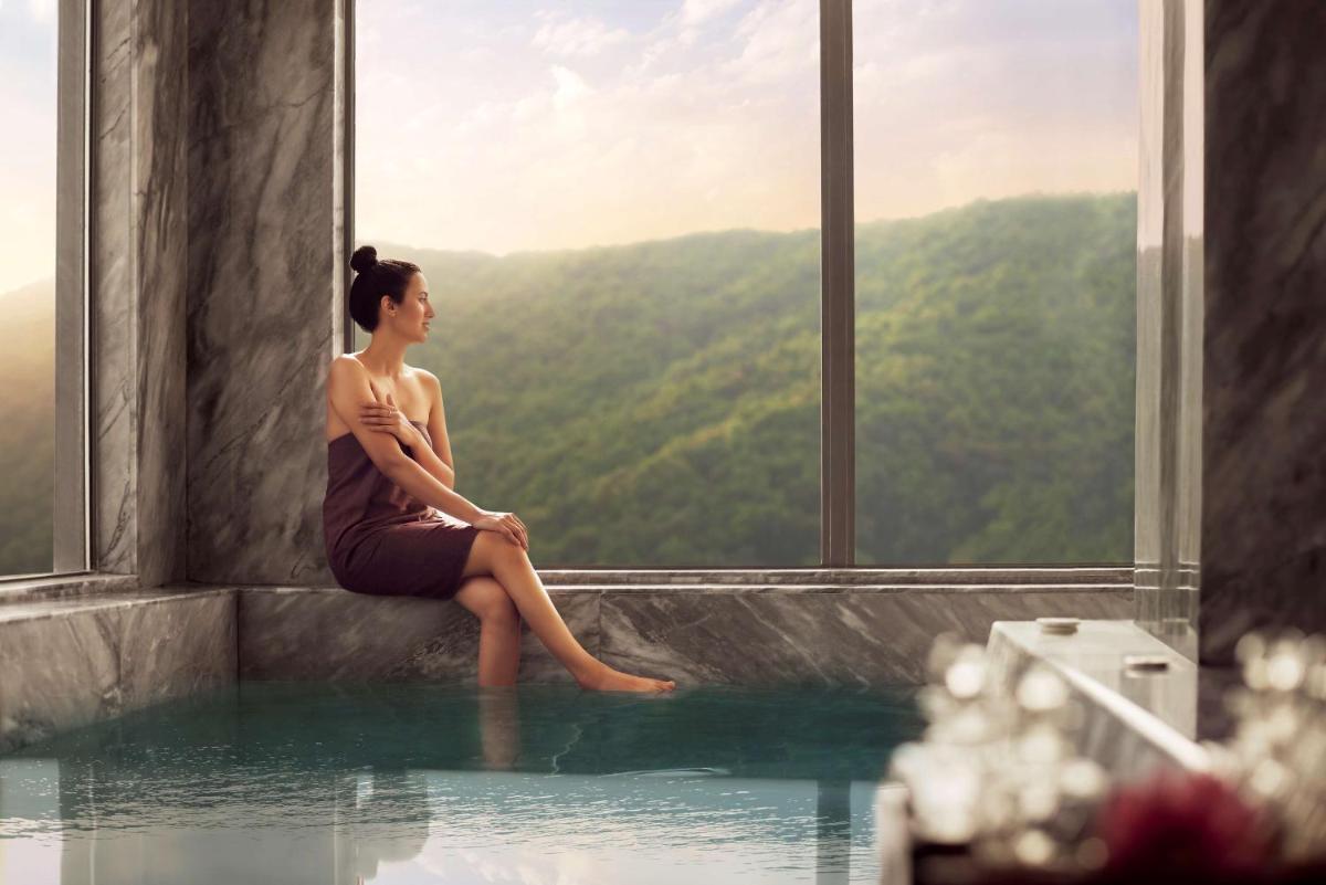 a woman sitting in a pool of water in a building at Hyatt Regency Dehradun Resort and Spa in Dehradun