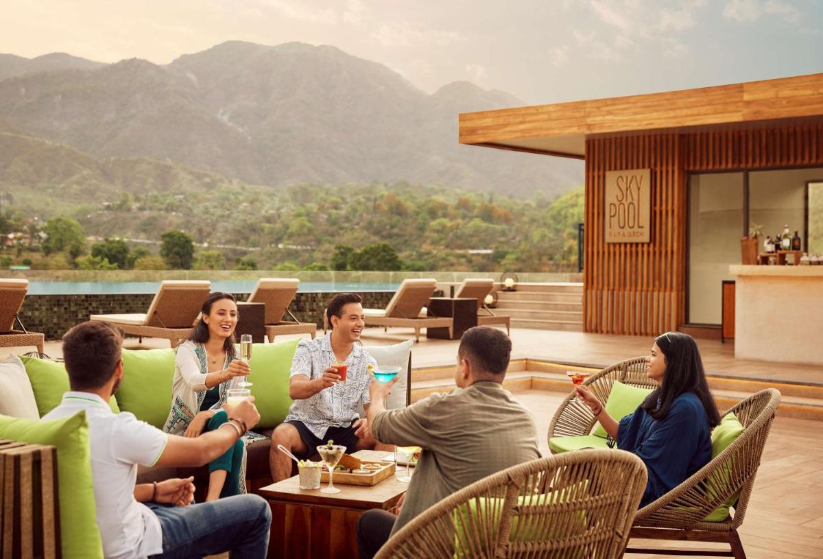 a group of people sitting around a table on a patio at Hyatt Regency Dehradun Resort and Spa in Dehradun