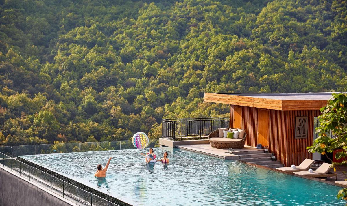 a group of people in the water at a swimming pool at Hyatt Regency Dehradun Resort and Spa in Dehradun