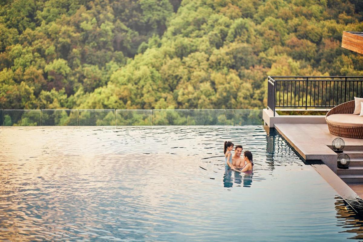a couple of dogs swimming in a lake at Hyatt Regency Dehradun Resort and Spa in Dehradun