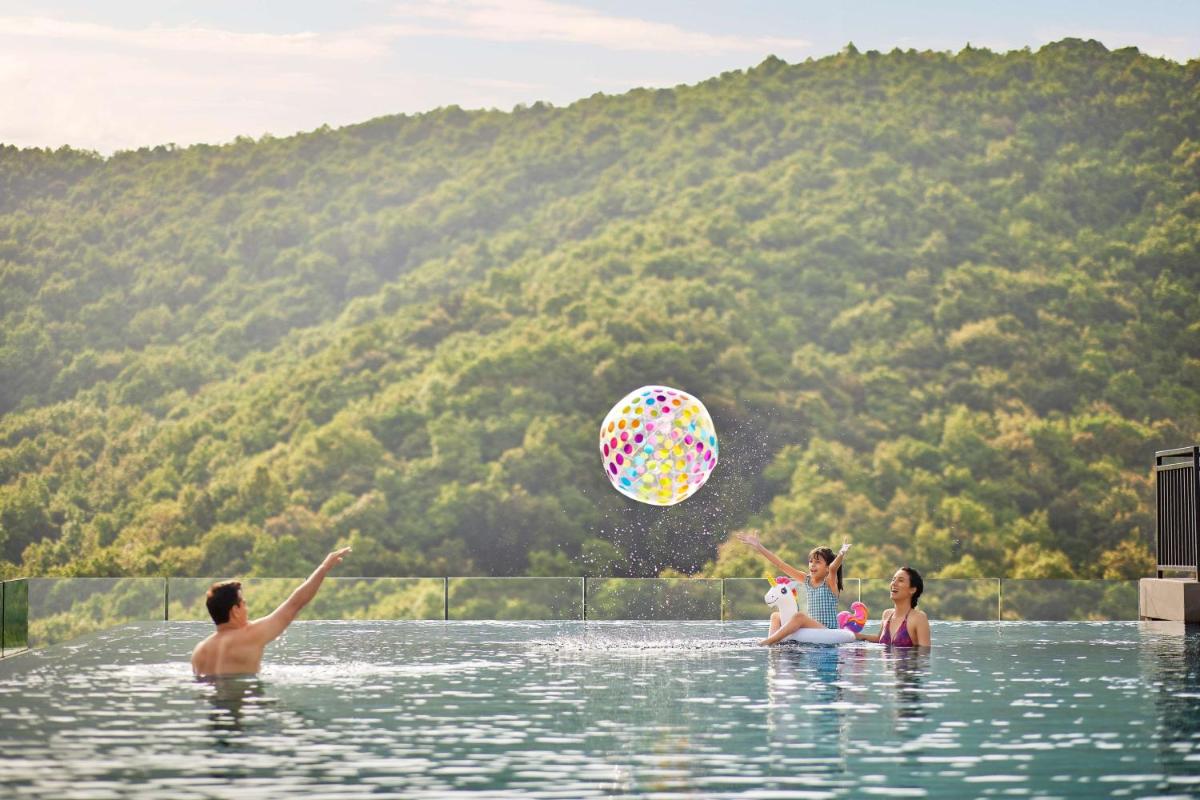 a group of people playing with a ball in the water at Hyatt Regency Dehradun Resort and Spa in Dehradun