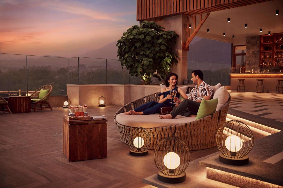 a man and woman sitting on a couch in a living room at Hyatt Regency Dehradun Resort and Spa in Dehradun