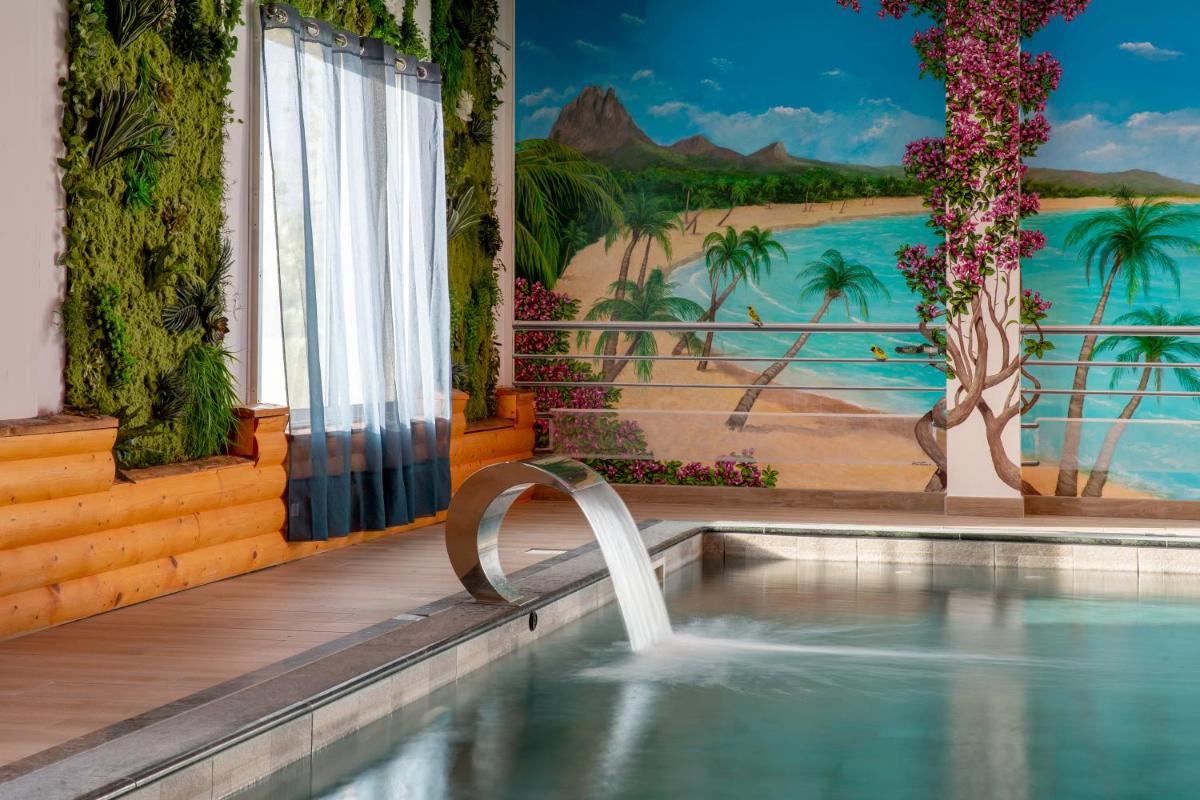 une piscine avec une fontaine dans un complexe hôtelier dans l'établissement Best Western Hotel & SPA Pau Lescar Aeroport, à Lescar