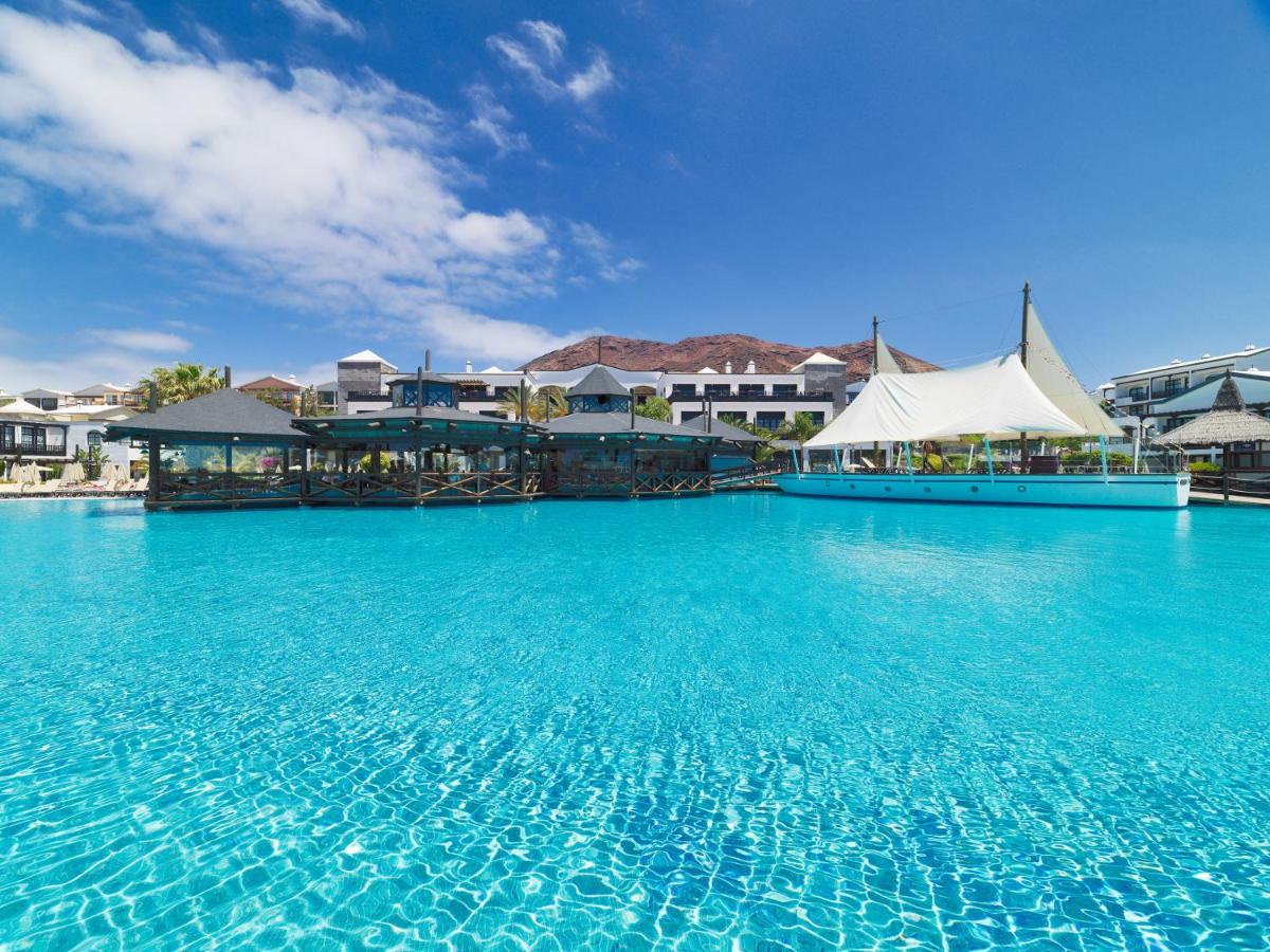 Una gran piscina de agua azul en un complejo turístico. en H10 Rubicón Horizons Collection, en Playa Blanca