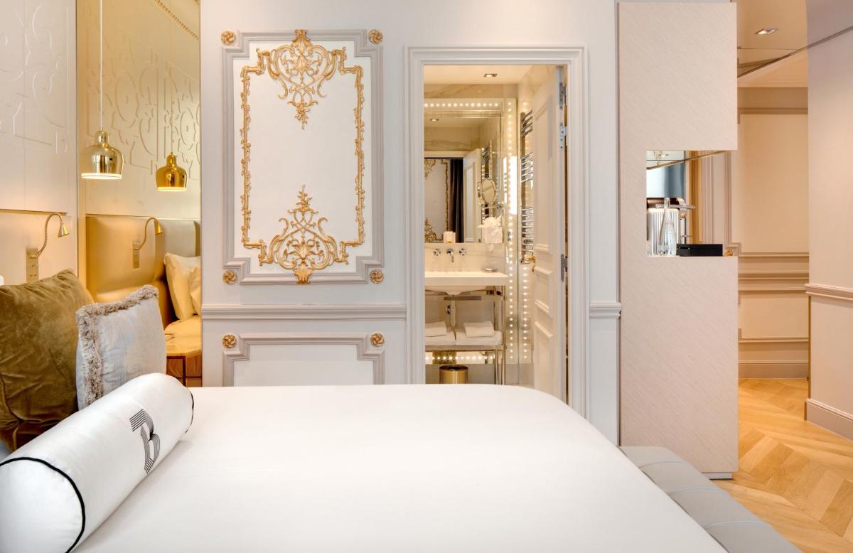 une chambre avec un lit blanc et une salle de bain dans l'établissement Hotel Bowmann, à Paris